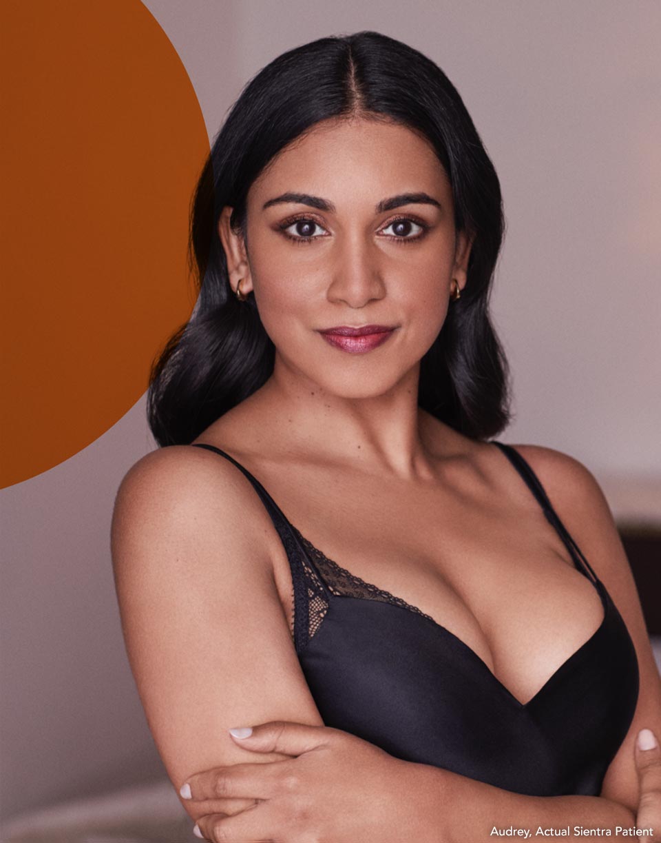 patiente avec les bras croisés, souriant au spectateur